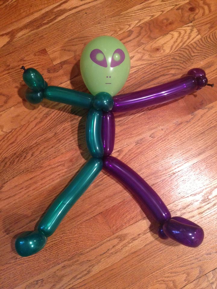 A whimsical balloon figure resembling a green alien
