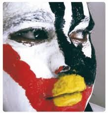 A face adorned with dramatic face paint in bold colors