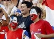 Fans enthusiastically support their team, displaying painted faces