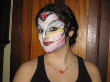 A woman poses with elaborate face paint featuring colorful patterns and designs