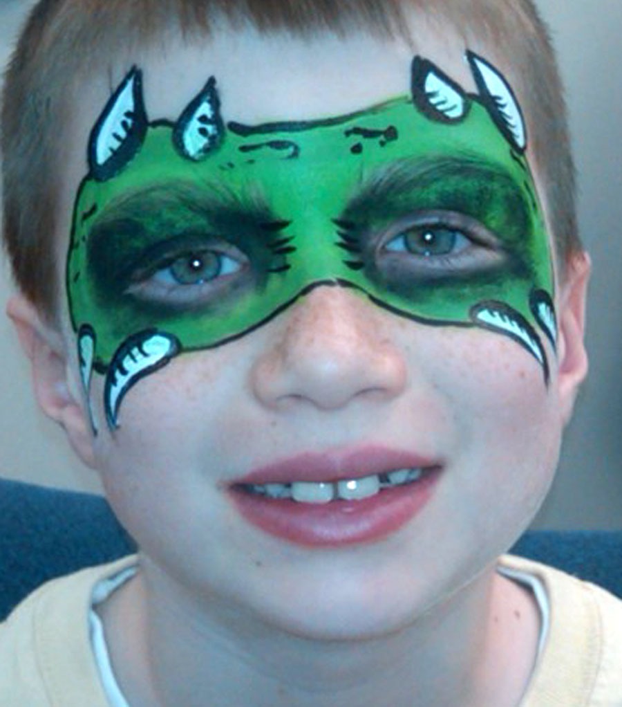 A boy with face paint resembling a green monster