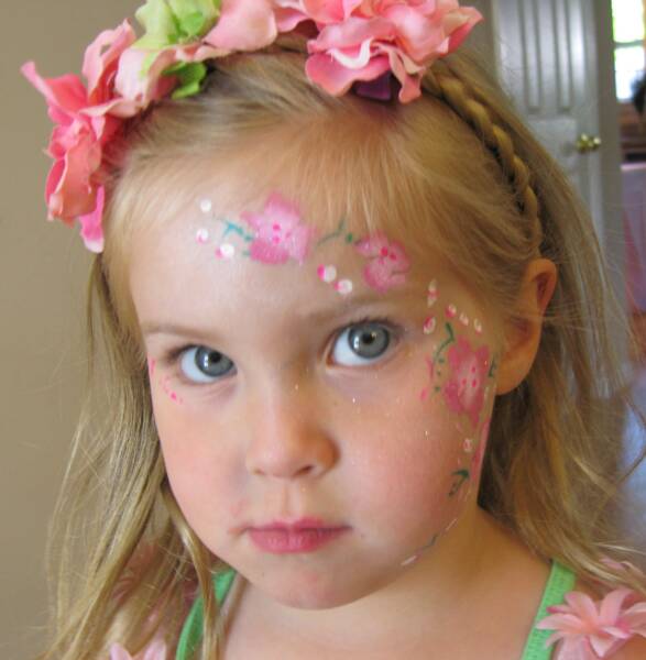 A young girl with a floral headband and face paint
